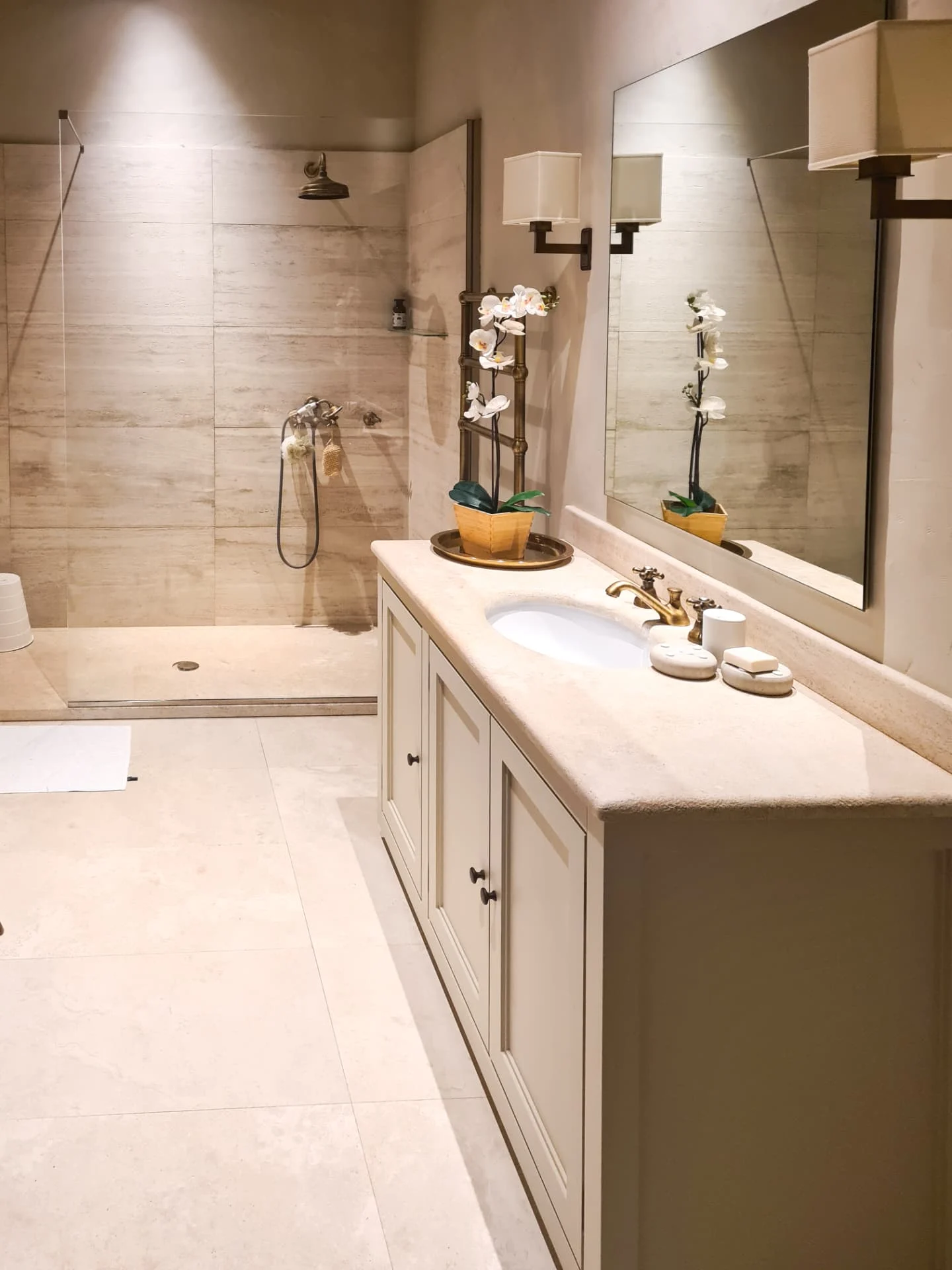 Bagno padronale in travertino con doccia a filo pavimento